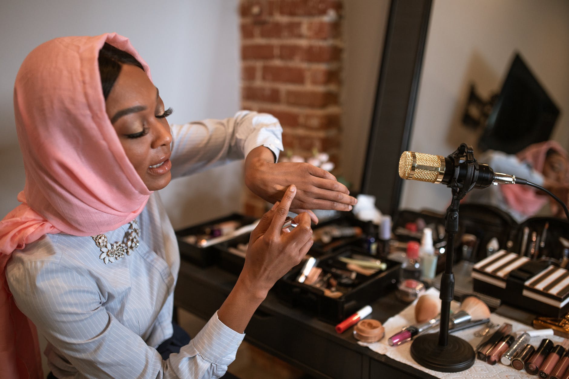 female vlogger in pink hijab doing a product test